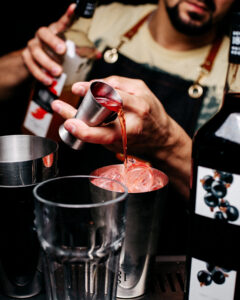 Roter Cocktail beim Zubereiten im Shaker.