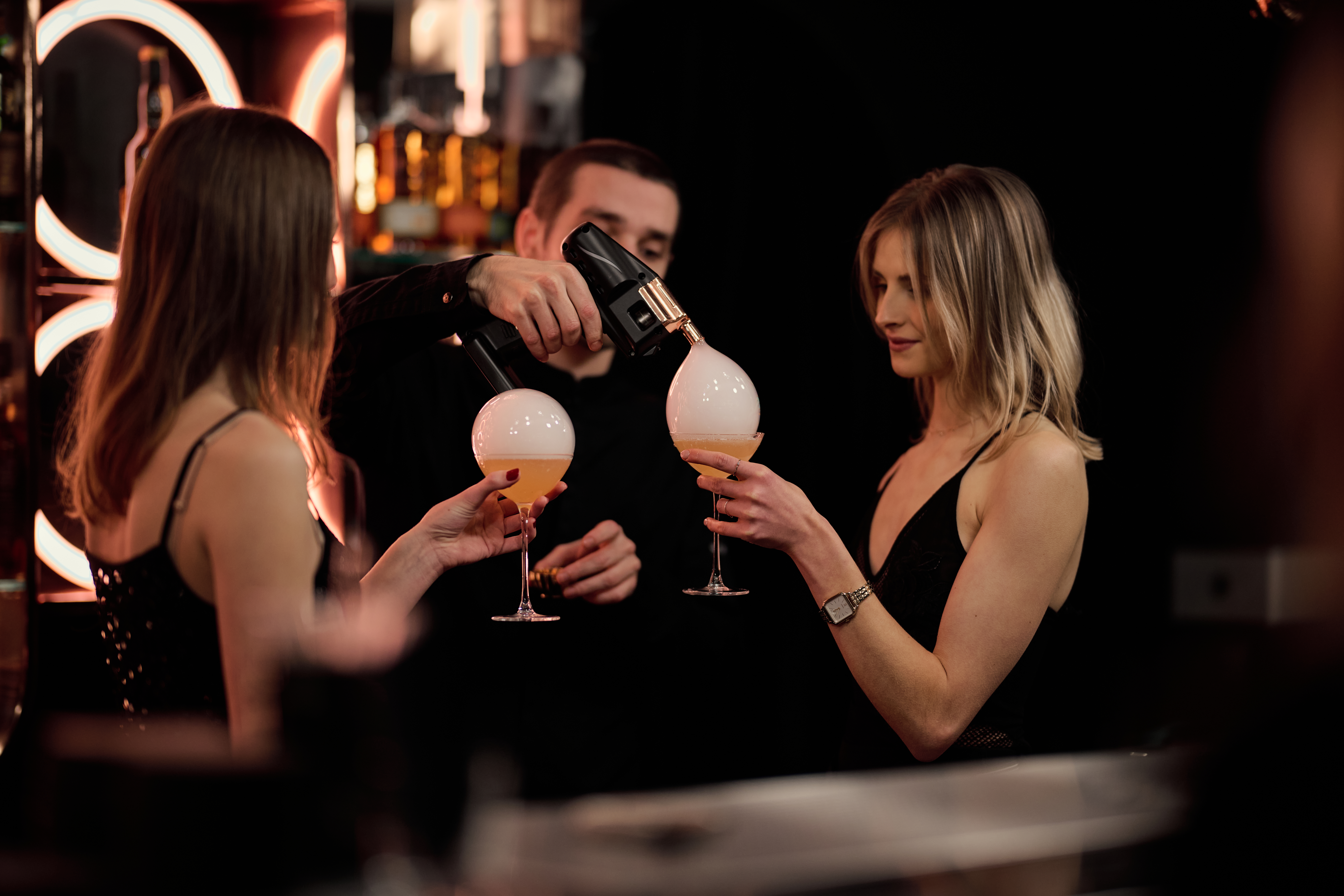Zwei Frauen haben Cocktails mit Bubble in der Hand.