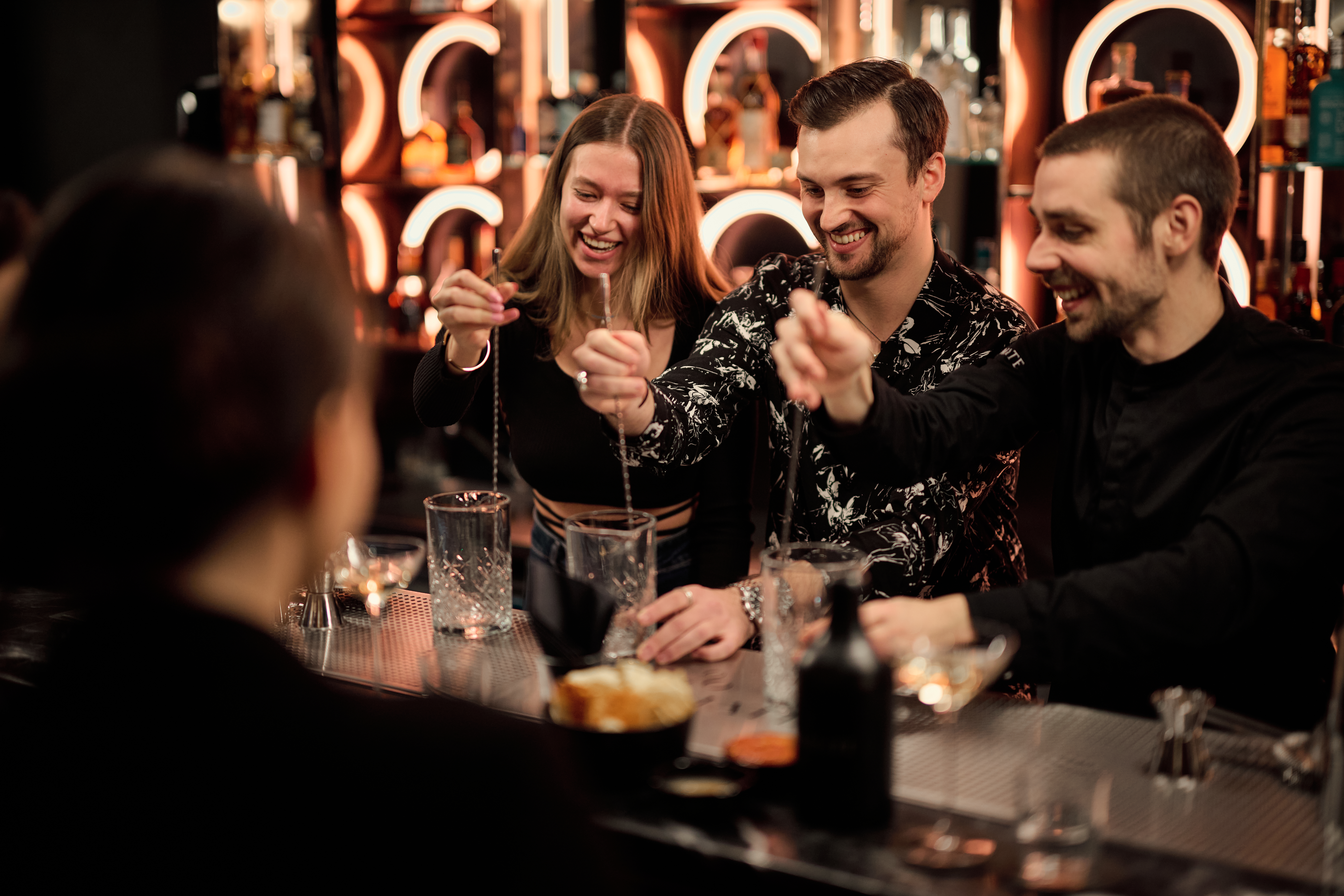 Firmenevent Cocktailkurs Cocktails Rühren mit zwei Frauen und einem mann