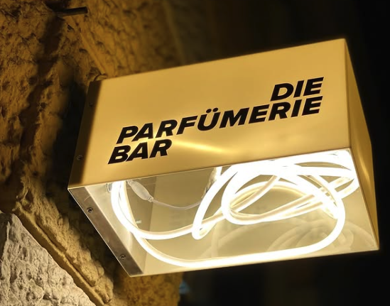 Man sieht das Eingangsschild, ein weißes quadrat als Lampe mit dem Logo