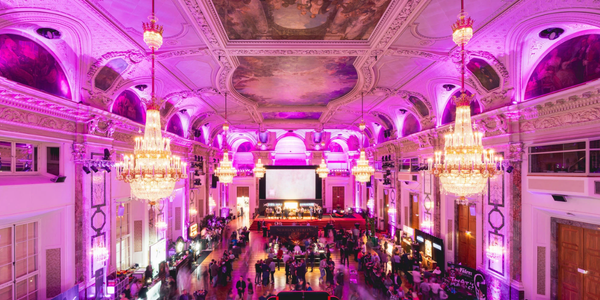 Der Saal der Hofburg in pink beleuchtet mit den Ständen